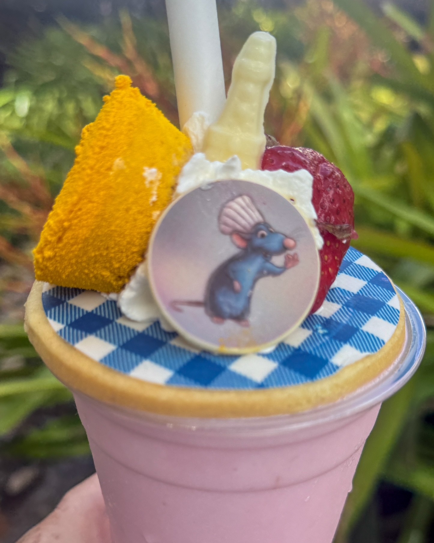 a pink cup with a blue and white checkered top and a cartoon mouse on it