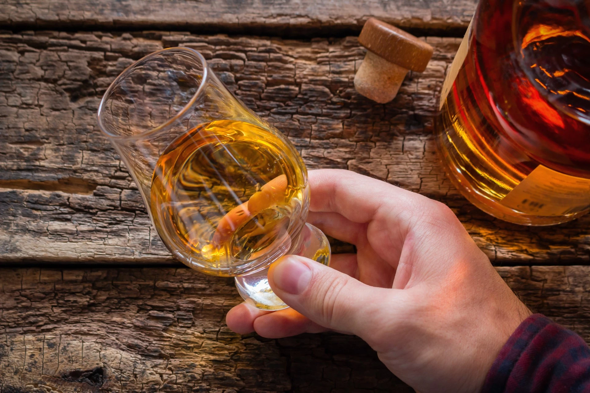 a hand holding a glass of alcohol