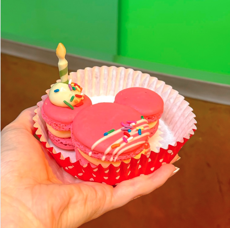 a hand holding a cupcake