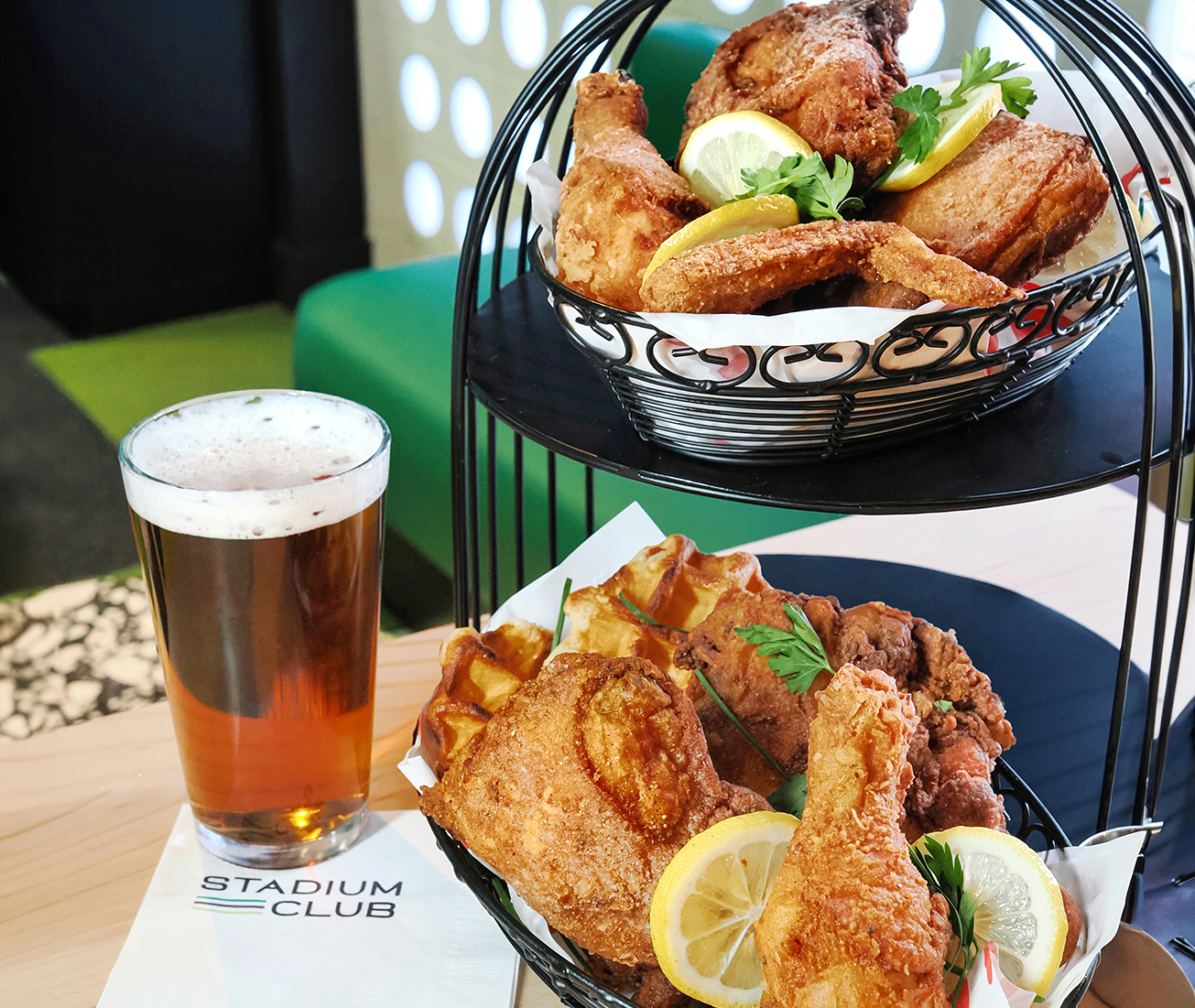 a two tiered trays of fried chicken and a glass of beer