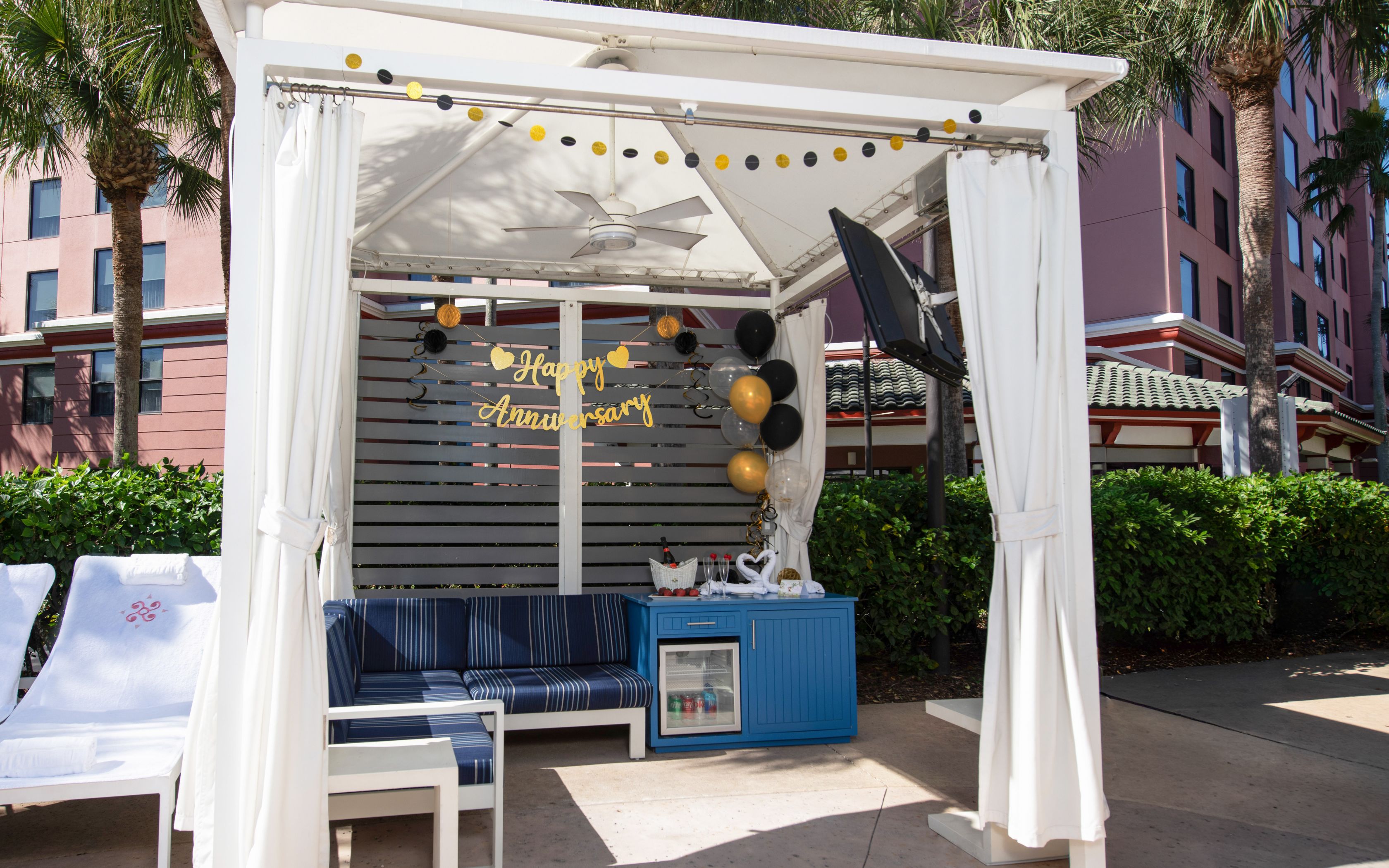 a white tent with blue and white furniture and balloons