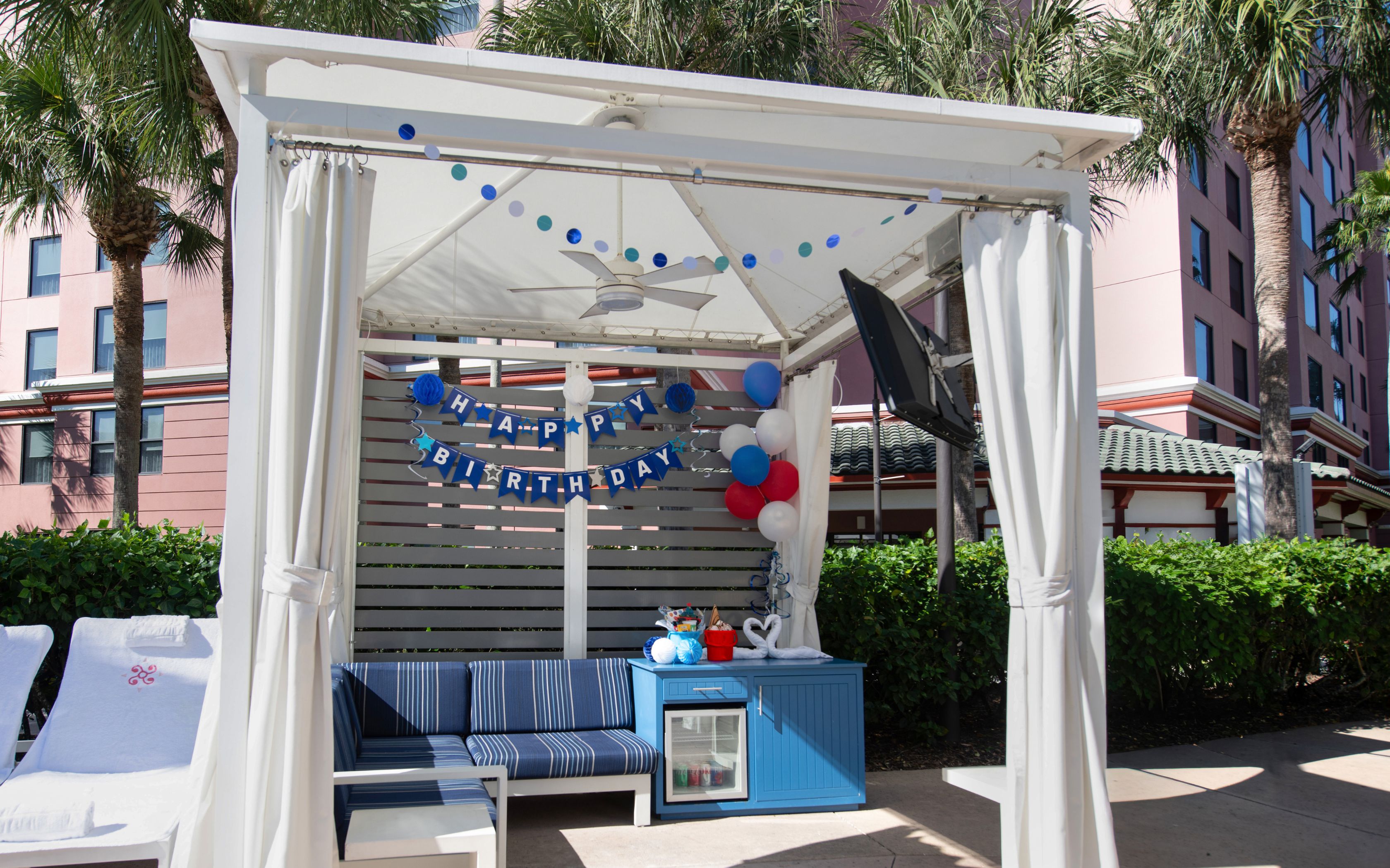 a white tent with blue and white chairs and a blue and white table