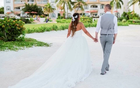 a man and woman walking down a road with a building in the background