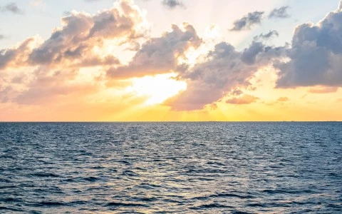 a body of water with clouds above it