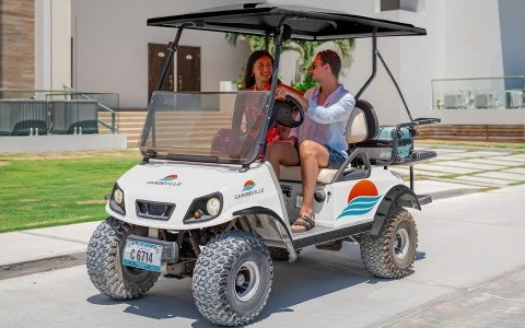 a man and woman riding a golf cart