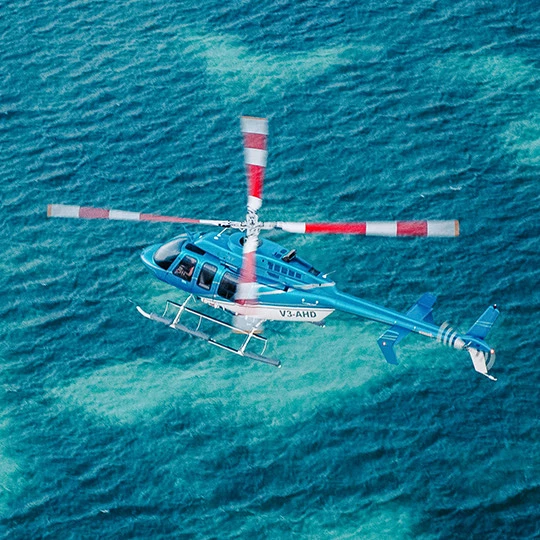 a helicopter flying over the ocean