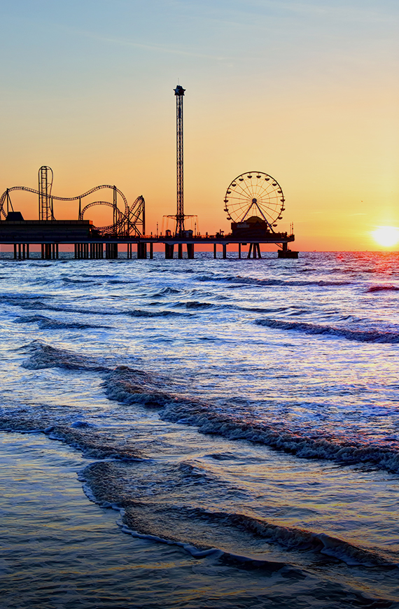 a pier and a ferris wheel at sunset