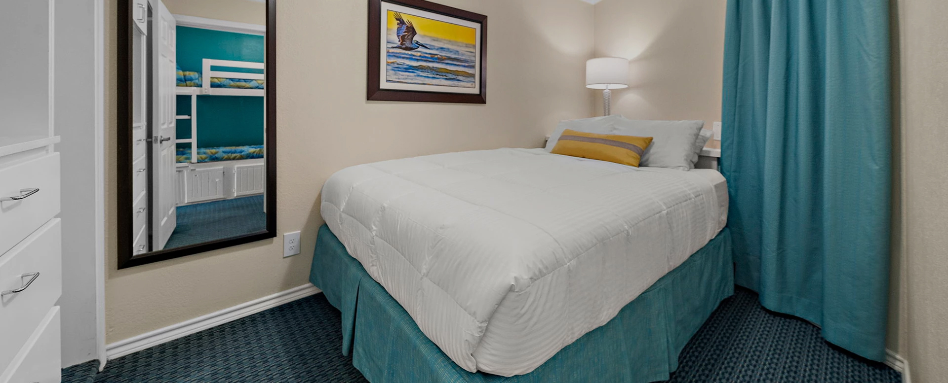 a bed with a lamp and a picture on the wall