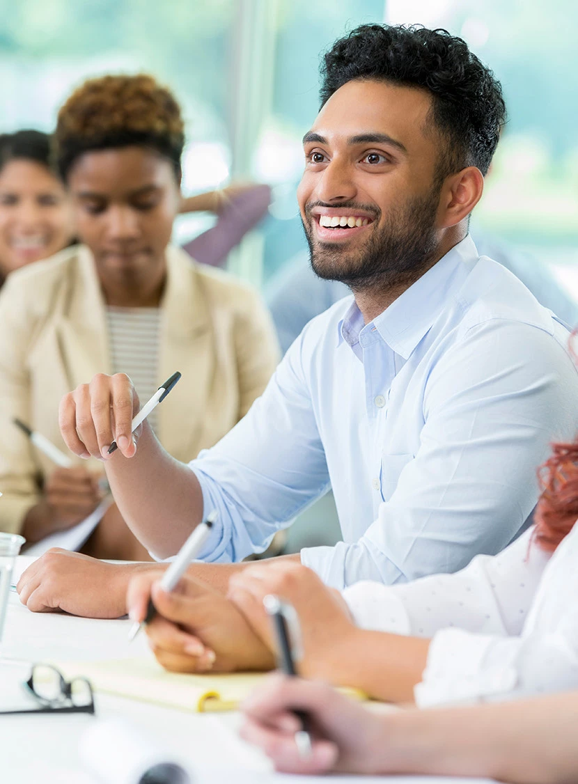 people sitting at a table with pens in their hands