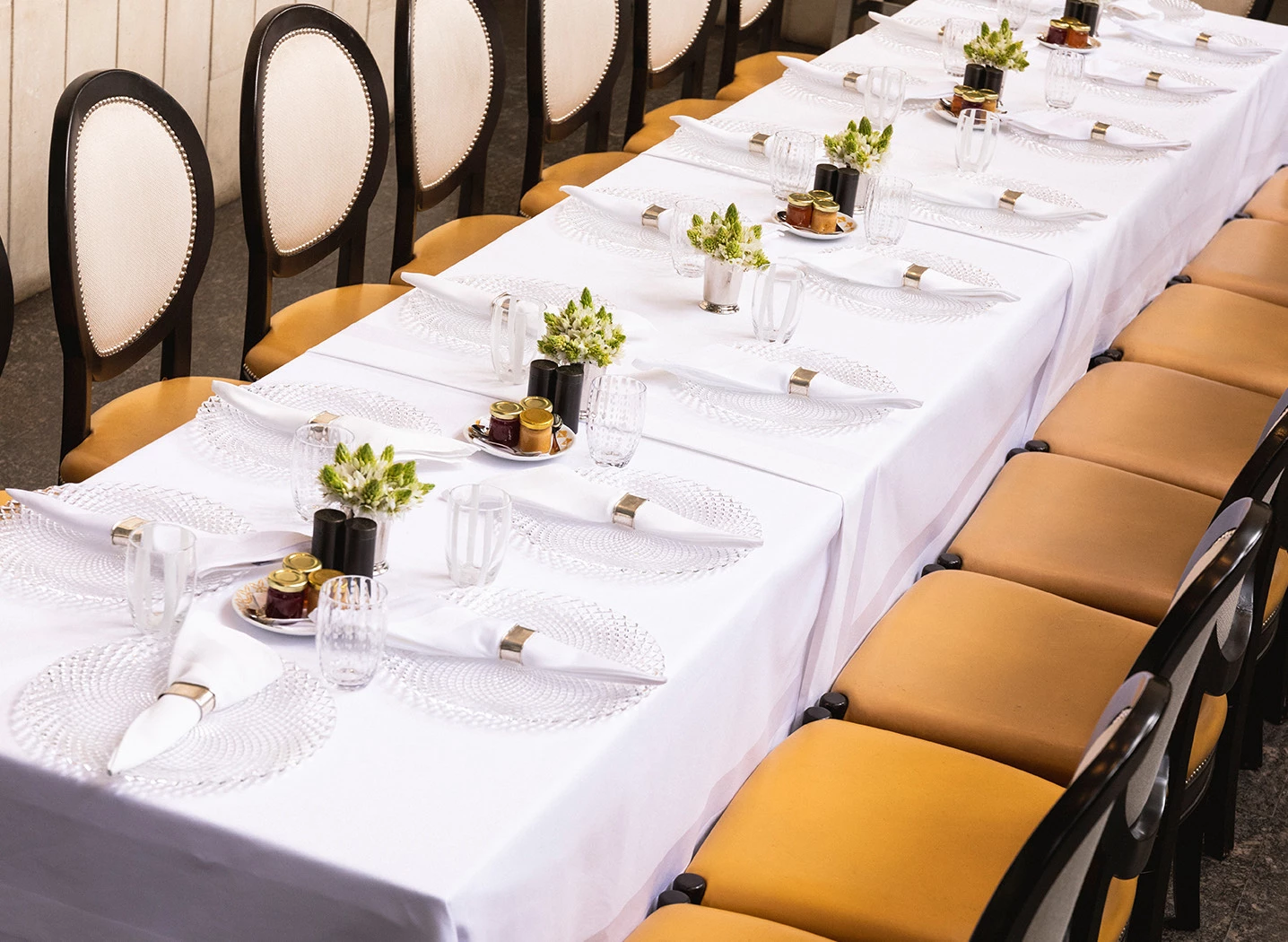 a set dining table with white linens and chairs