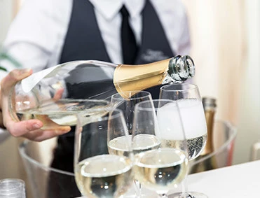 a person pouring champagne into a glass