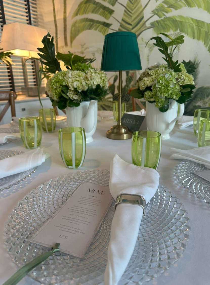 a table with green glasses and green glasses and a white napkin on it