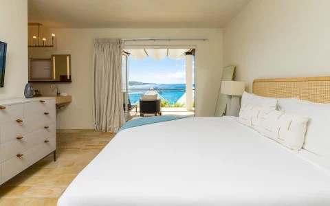 a bedroom with a large bed and a view of the ocean