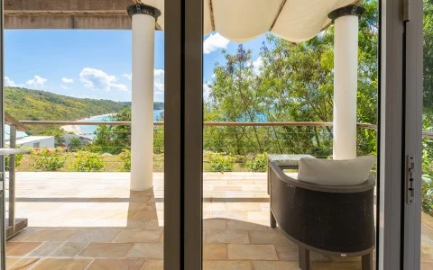 a chair on a patio with a view of the ocean