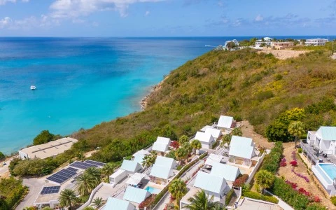 a group of houses on a hill by the ocean