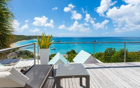 a deck with a table and chairs overlooking a body of water