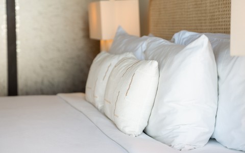 a bed with white pillows and a lamp