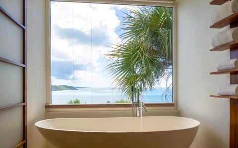 a bathtub with a window overlooking the ocean