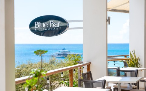 a restaurant with a view of the ocean and boats in the background