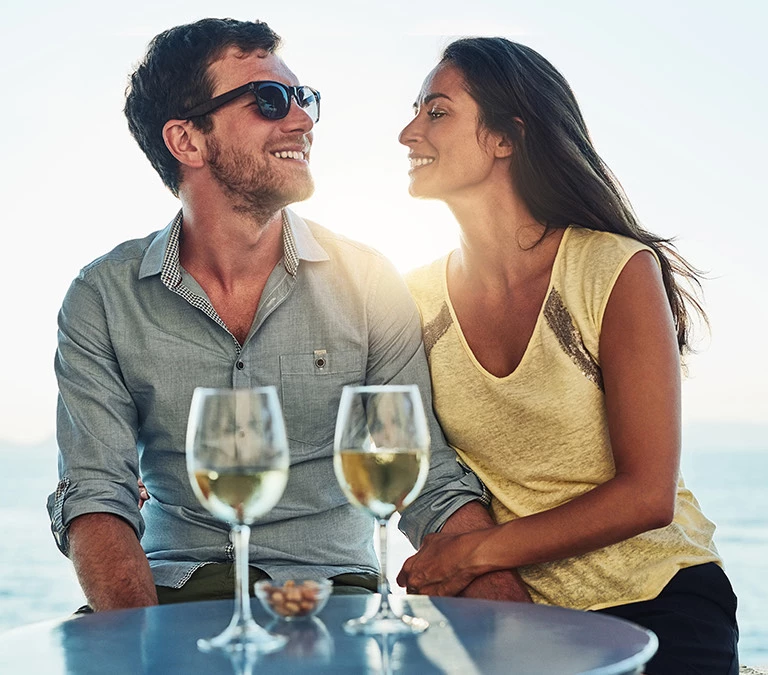 a man and a woman sitting at a table with wine glasses