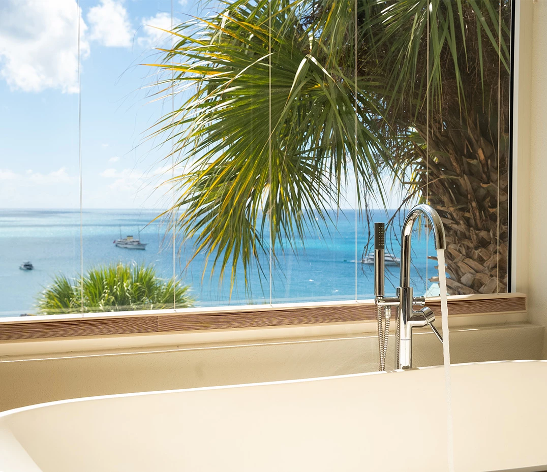 a bathtub with a view of the ocean and boats in the background