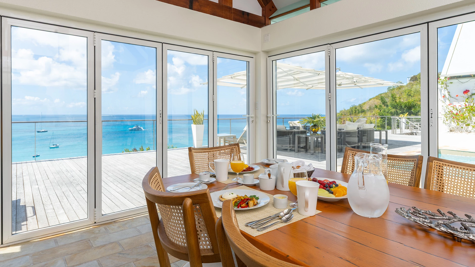 a table with food on it and a glass door with a view of the ocean
