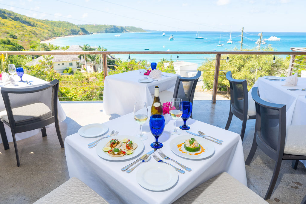 a table set for a dinner with a view of the ocean