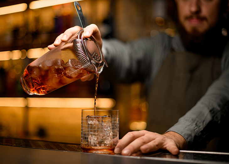 a person pouring a liquid into a jar