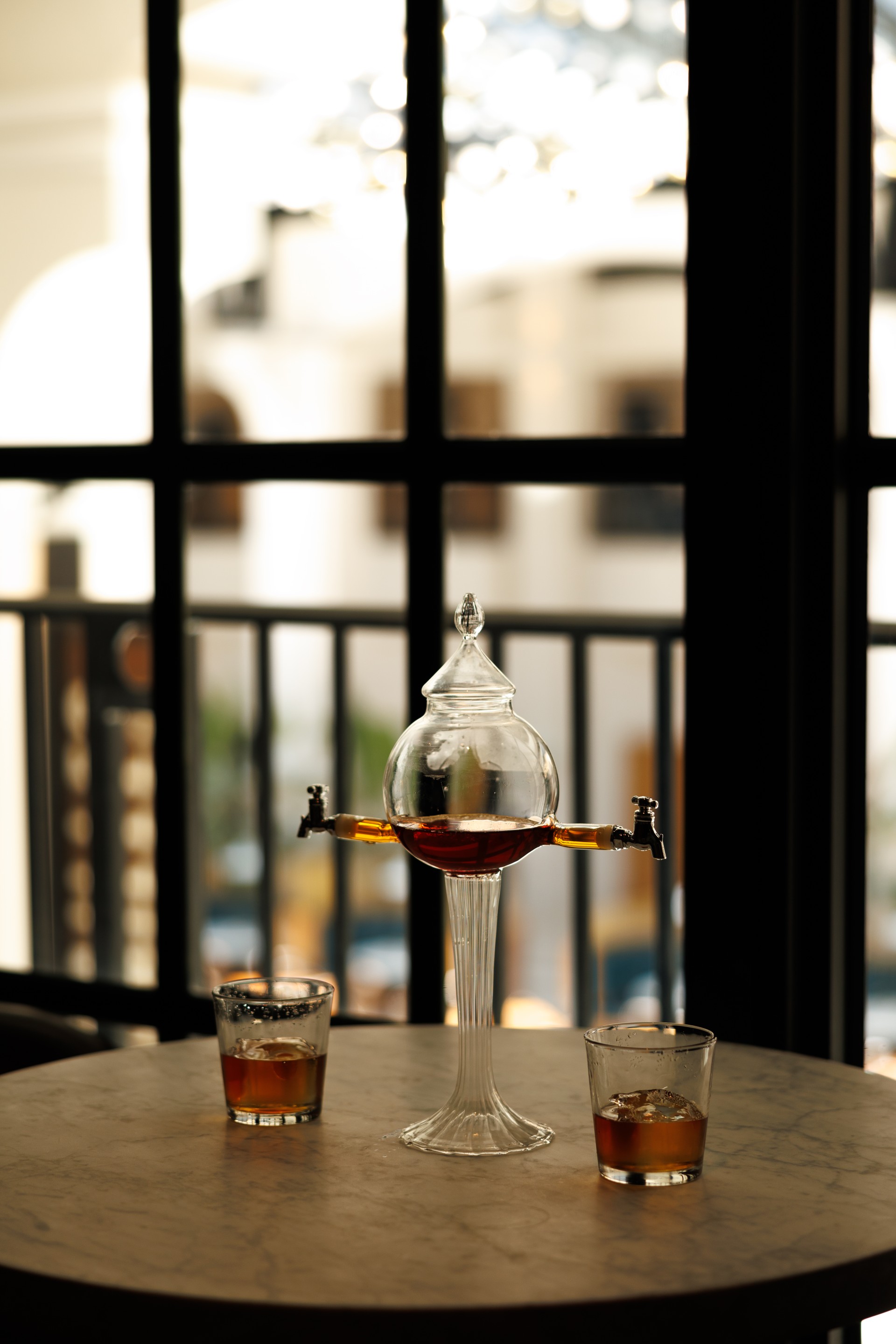 a glass container with a tap on top of a table