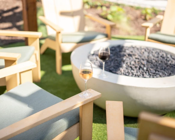 a glass of wine on a table next to a fire pit