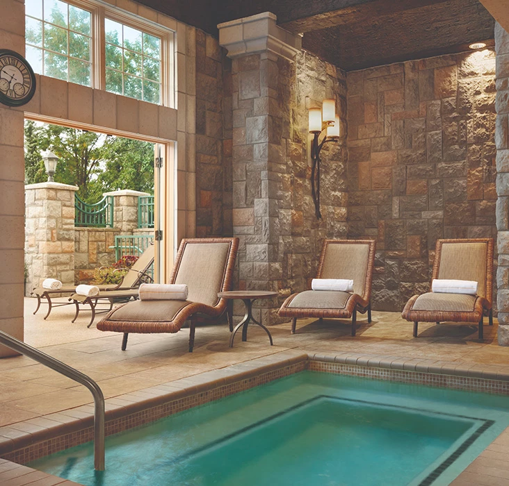 a swimming pool with chairs and a fireplace