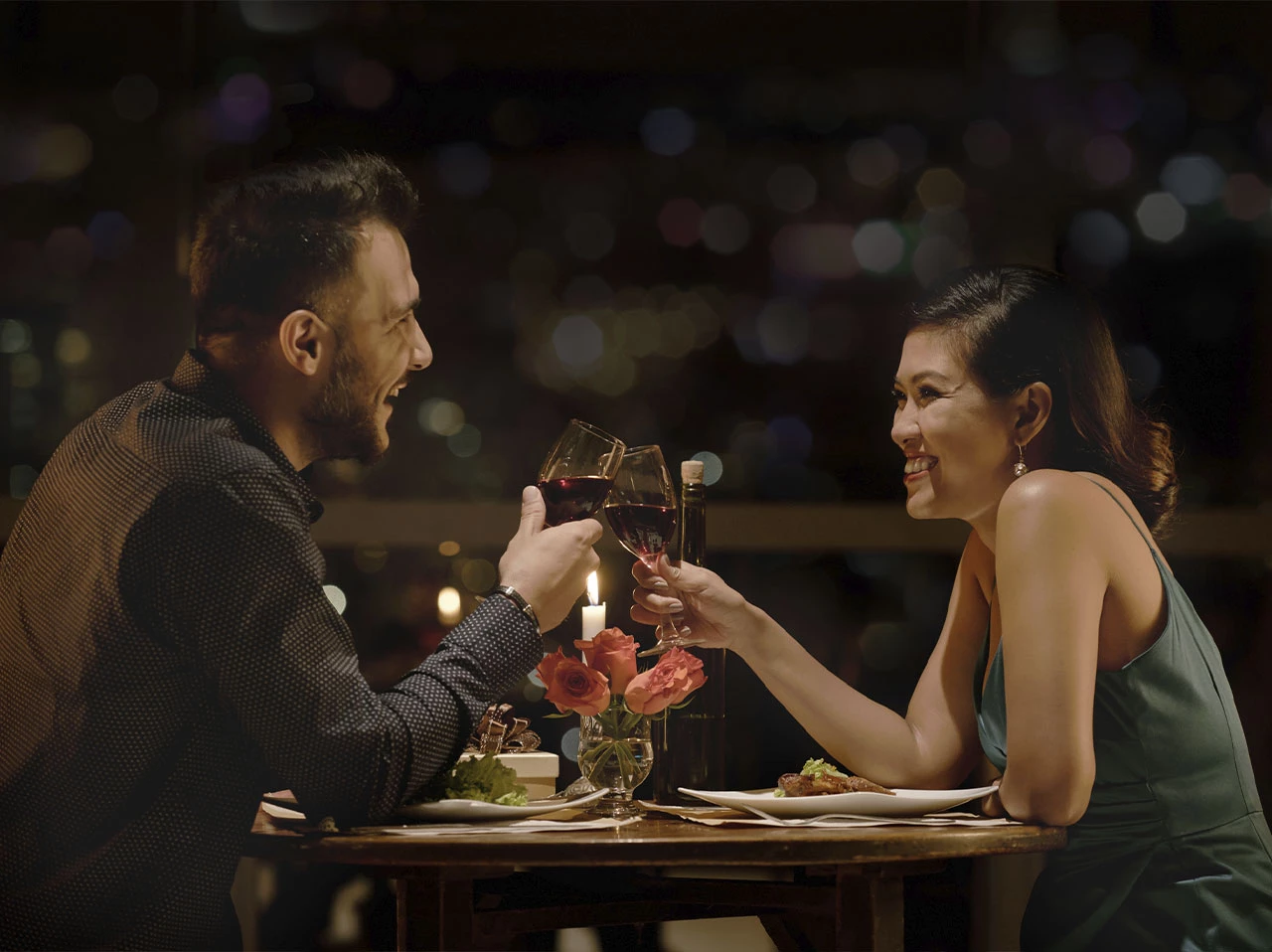 a man and woman sitting at a table with wine glasses