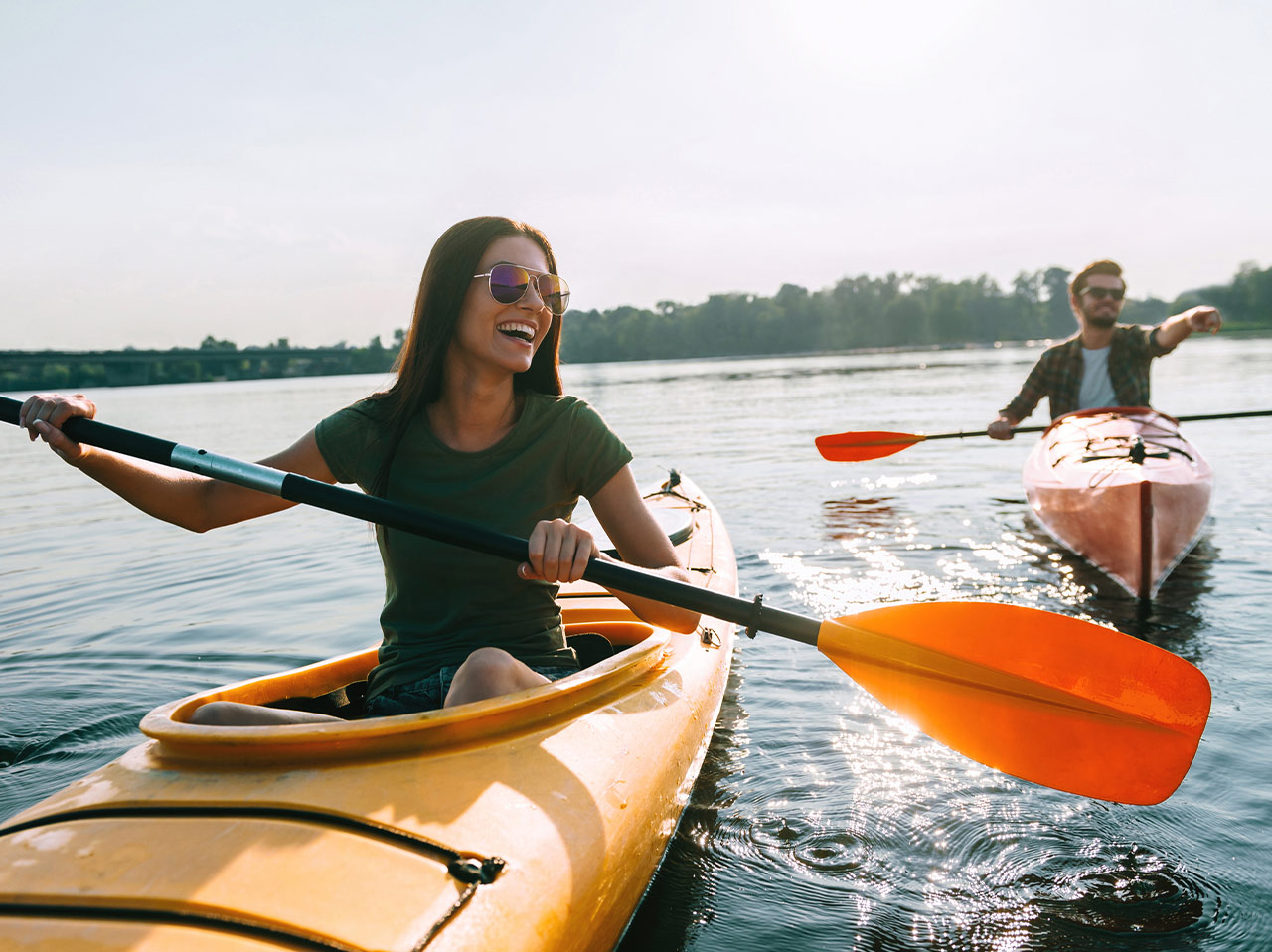 a woman in a kayak with a man in the background