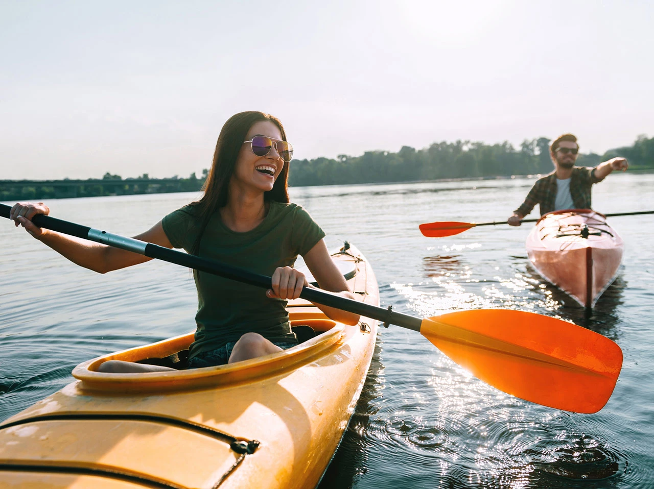 a woman in a kayak with a man in the background
