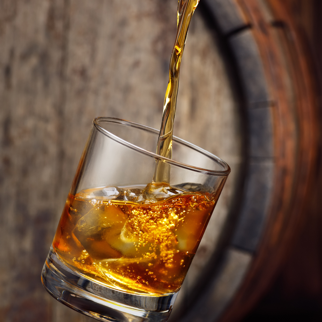 a glass of amber liquid being poured into a glass
