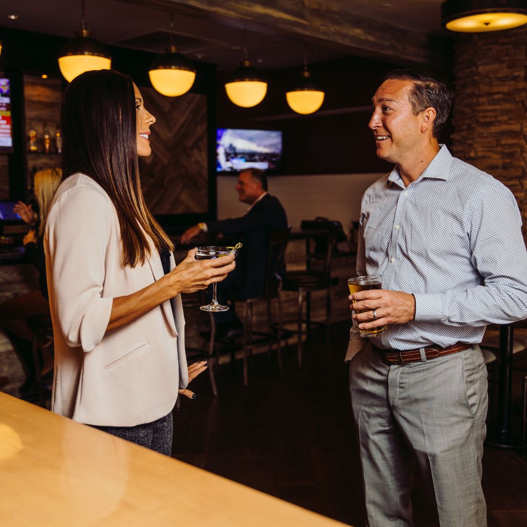 a man and woman holding drinks at the CK Pub at Cherry Valley Hotel
