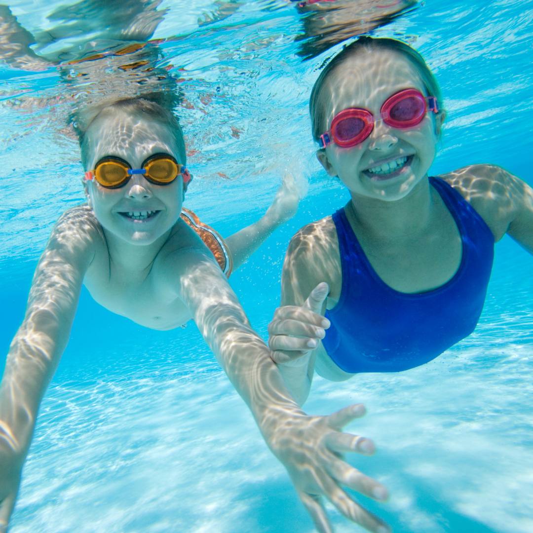 two children swimming underwater in a pool at cherry valley hotel 