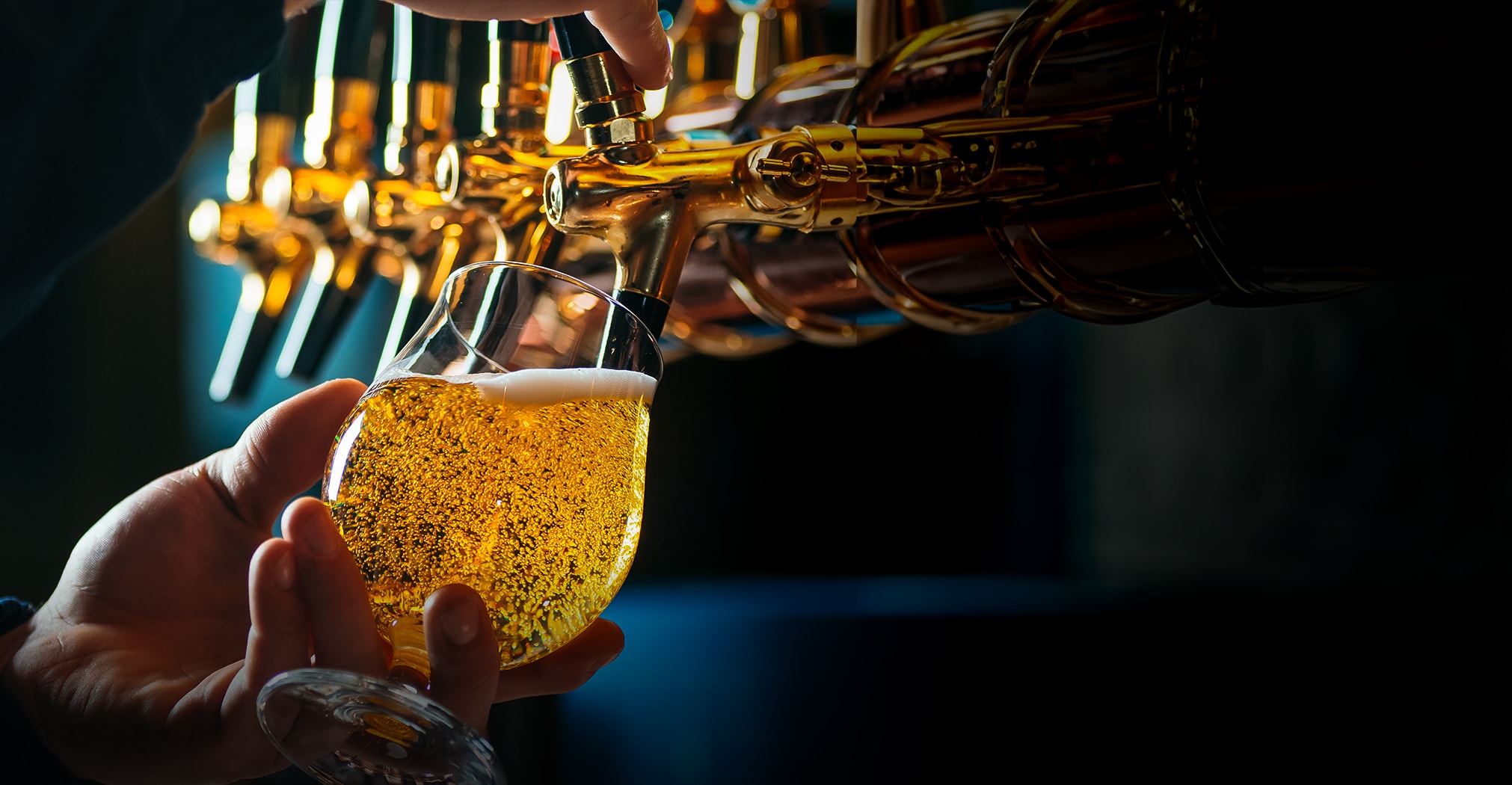 a person pouring a drink into a glass