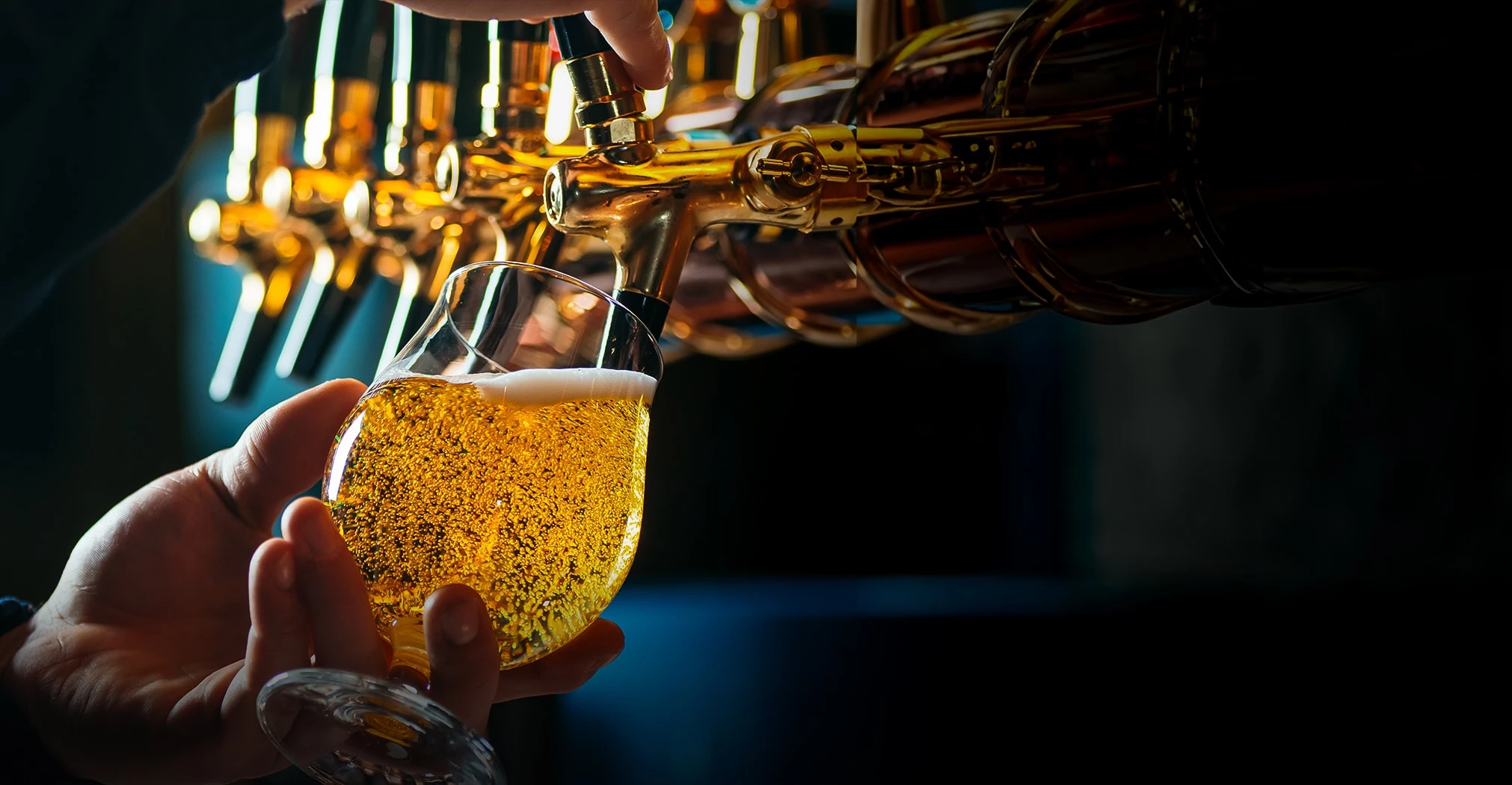 a person pouring a drink into a glass