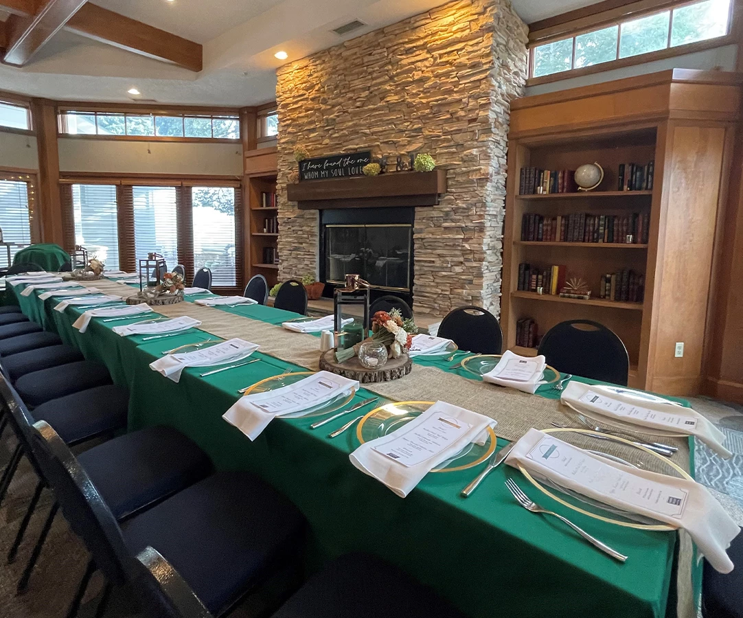 a long table with green cloths and silverware