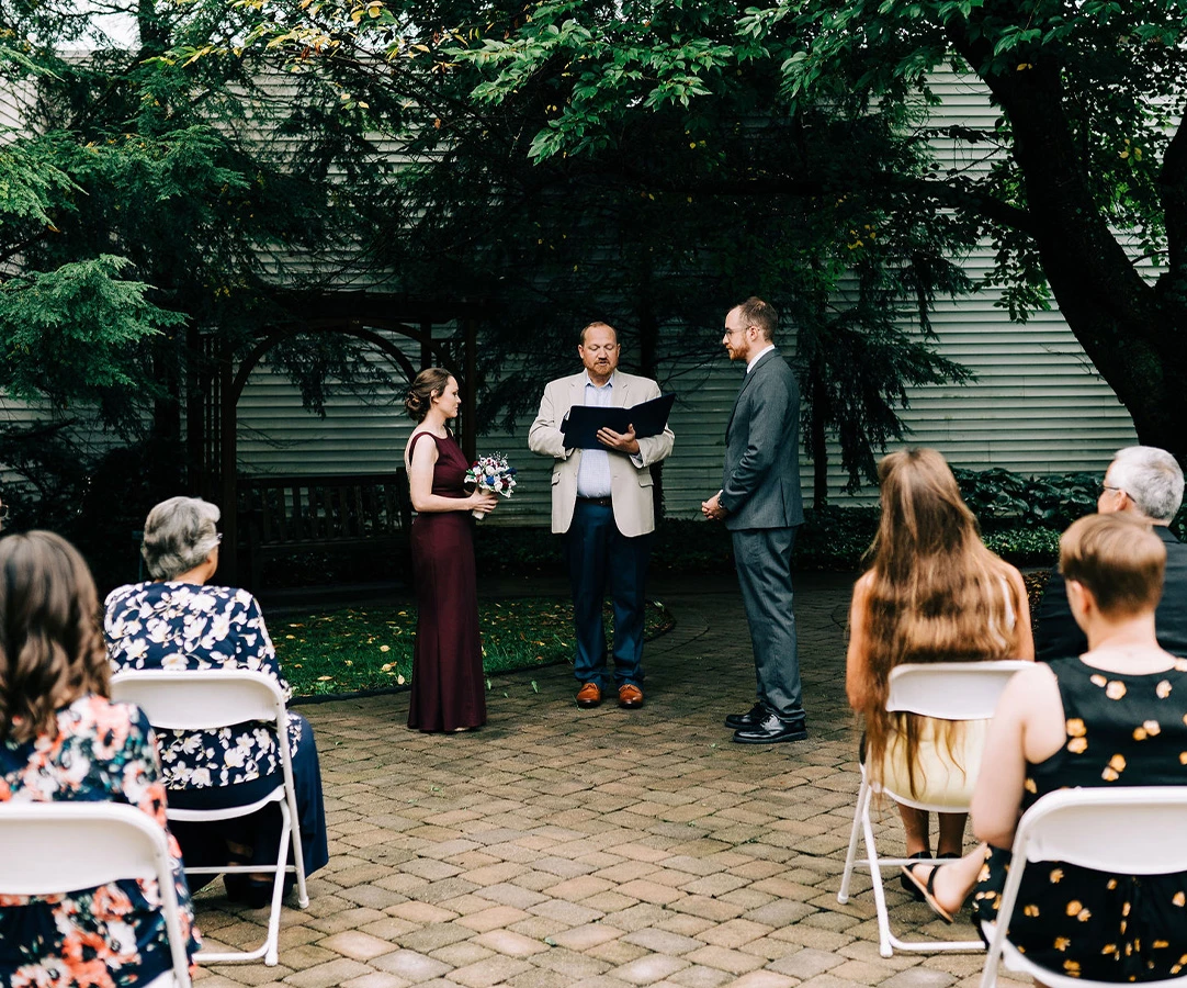 a man holding a book and a woman standing in front of a group of people