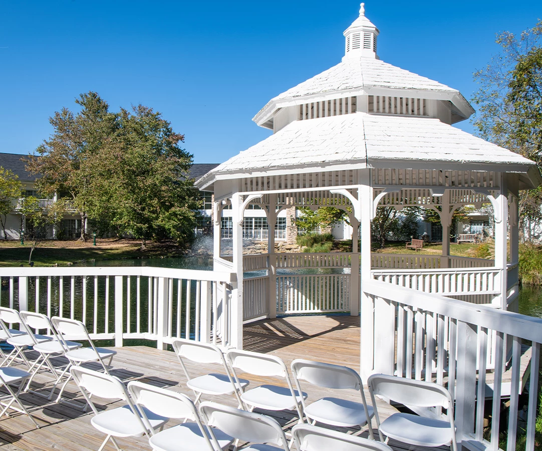 a white gazebo with chairs on a deck