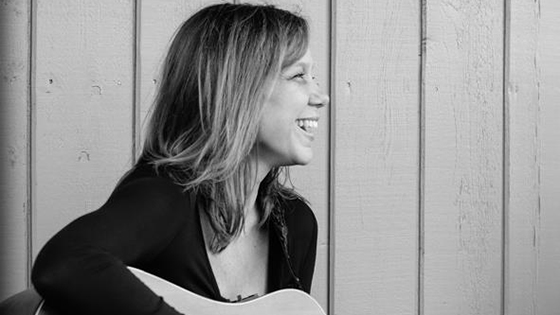 deanna sweeny smiling with a guitar