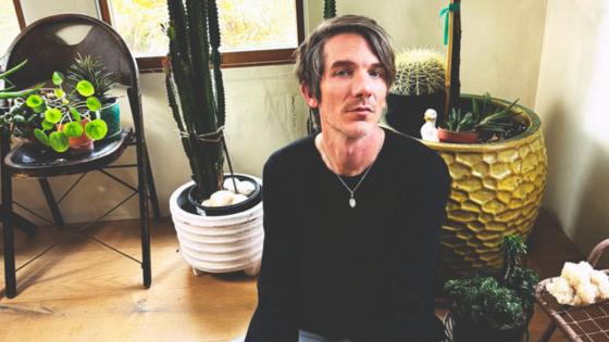 jonathan hape sitting in front of a plant