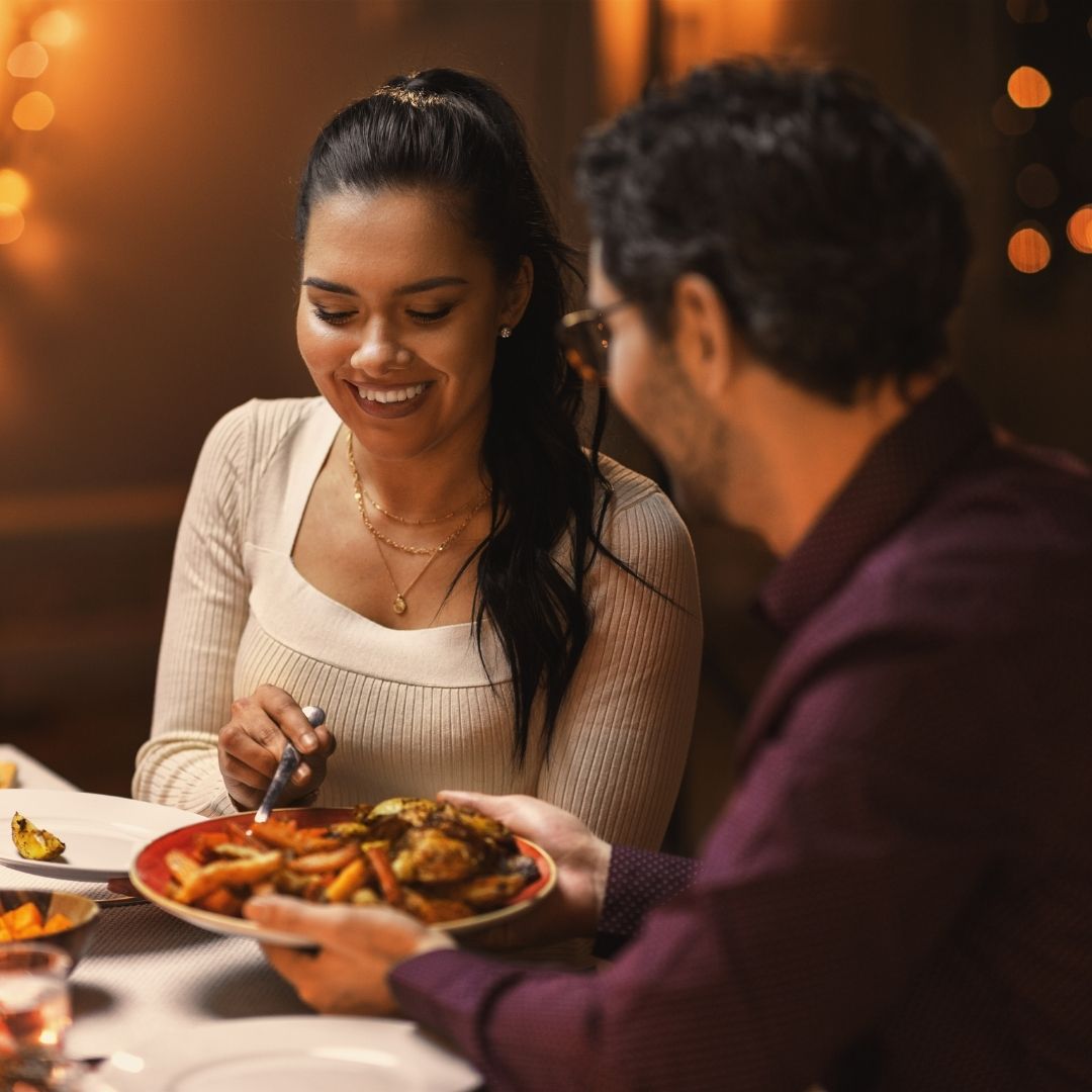 a man and woman sitting at a table with food at craftsman kitchen and terrace