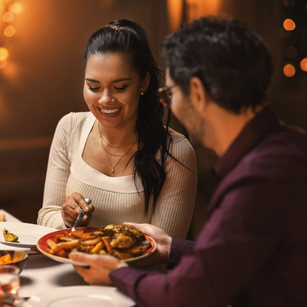 a man and woman sitting at a table with food at craftsman kitchen and terrace