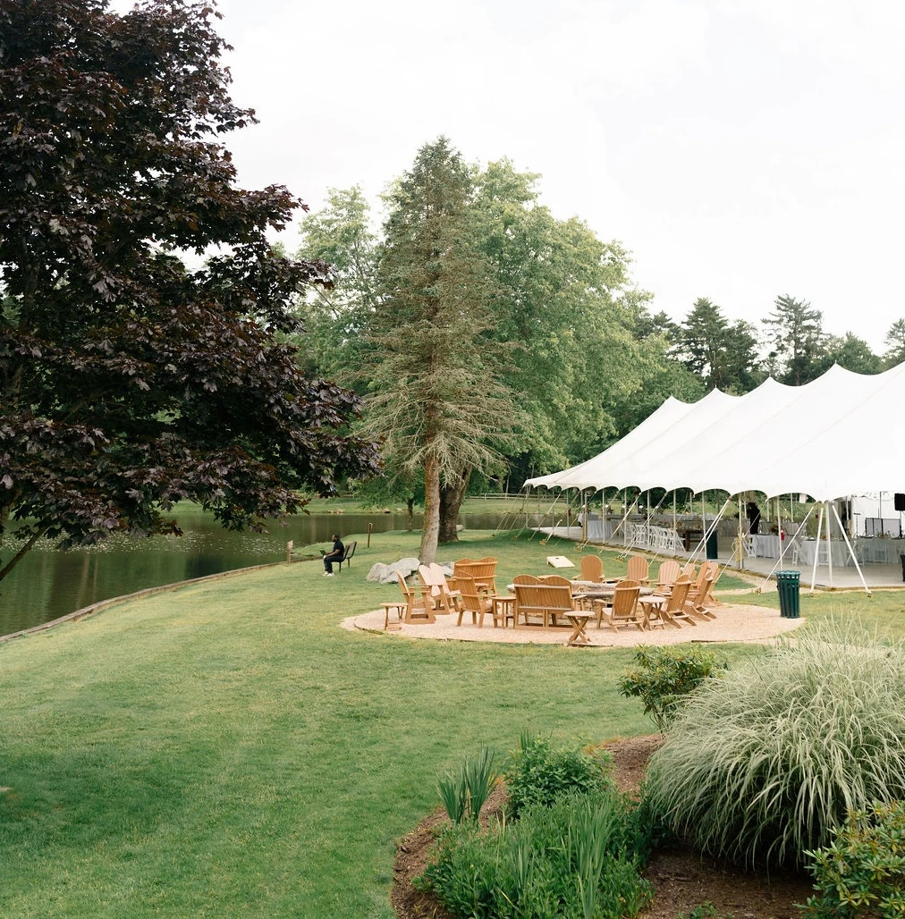 a white tent with a table and chairs in the middle of a lawn