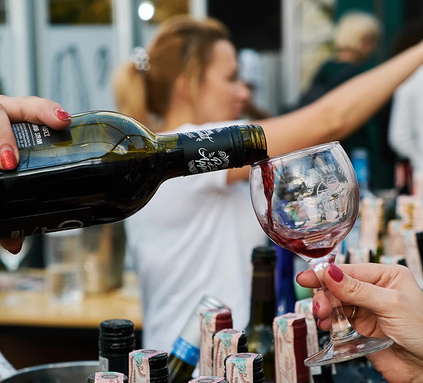 a person pouring wine into a glass