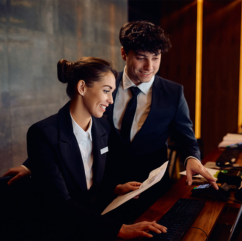 a man and woman looking at a computer