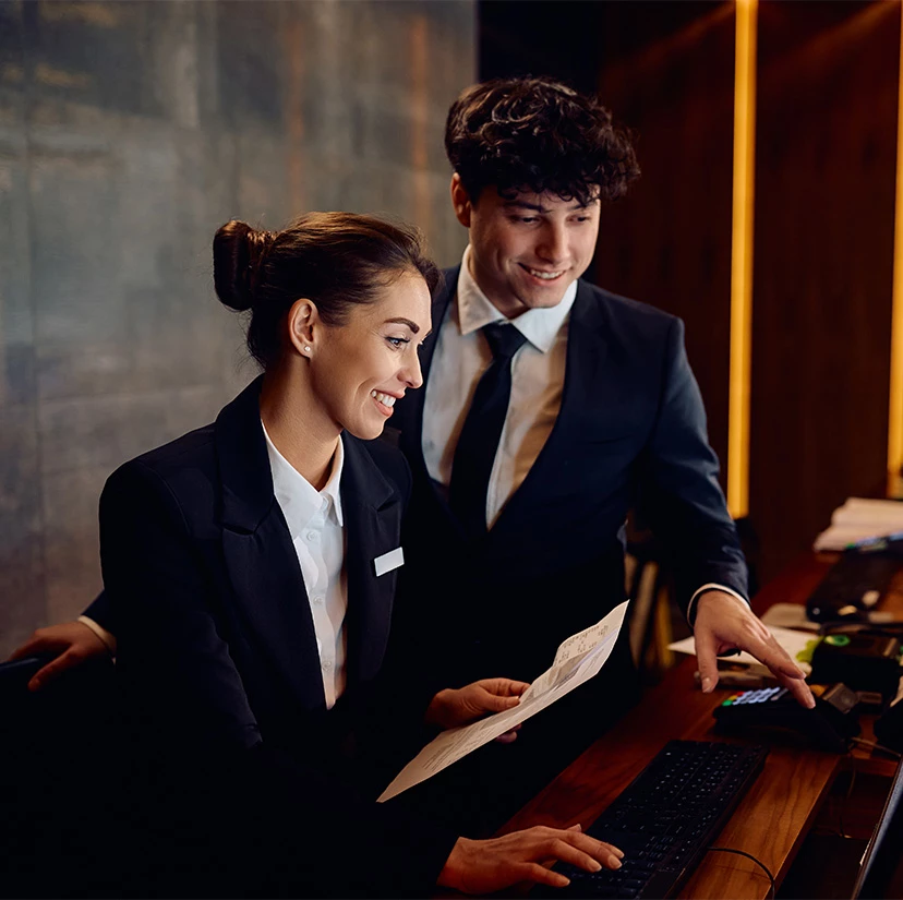 a man and woman looking at a computer